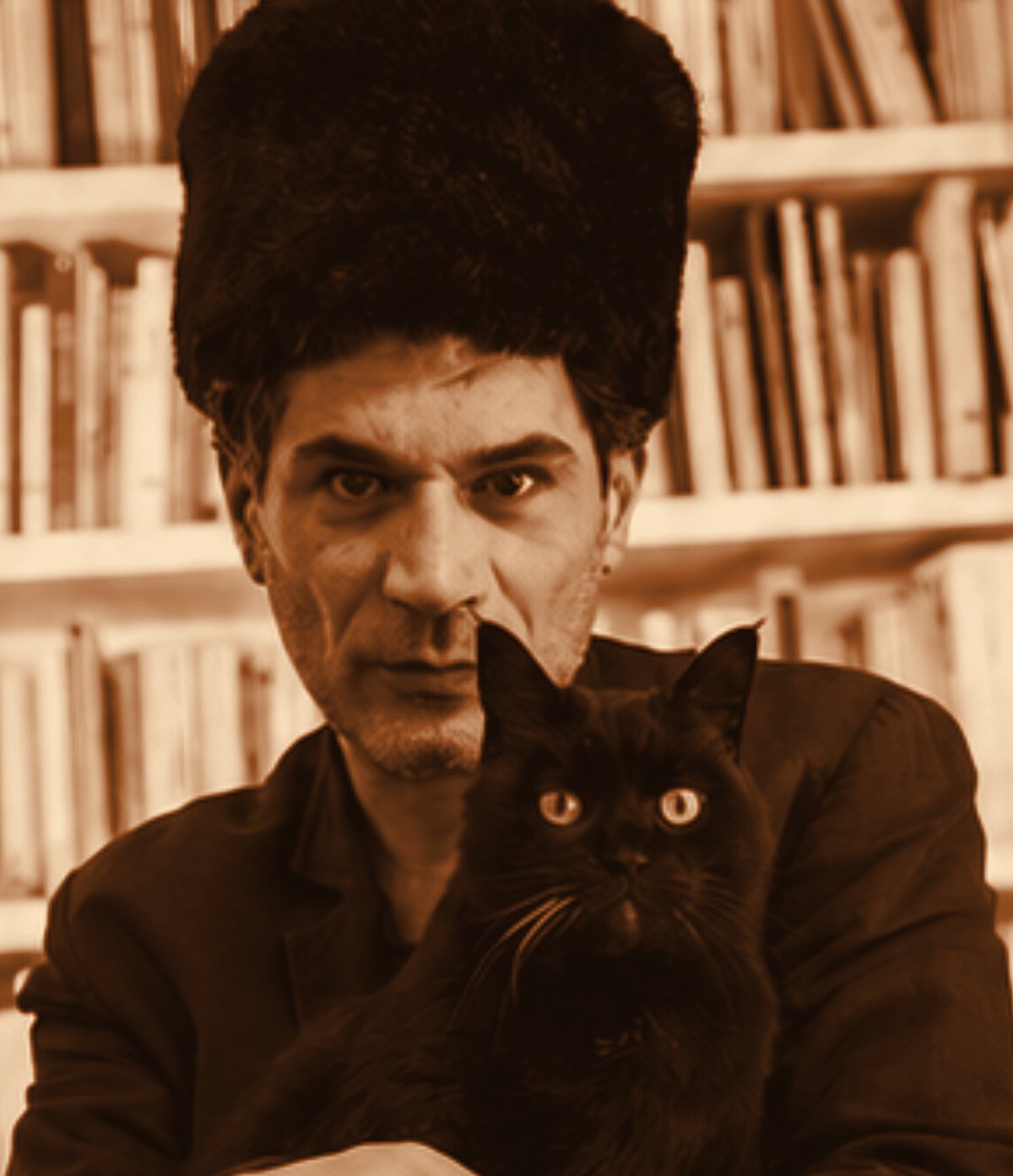Il cantautore Gerardo Balestrieri con un gatto nero, ritratto in toni caldi